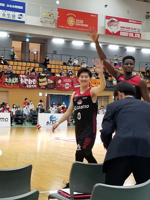 笑顔で手を振るバスケットボール選手