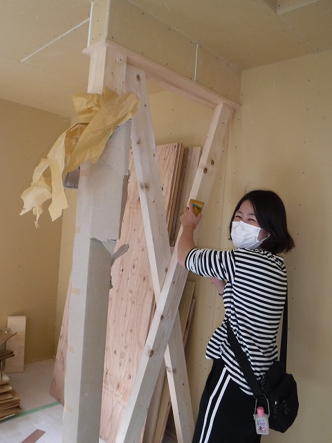 筋交いをやすり掛けする女性