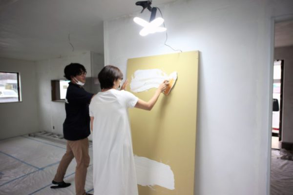 説明を受けながら漆喰塗りを体験している女性